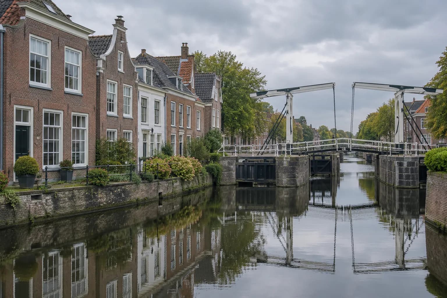Woningen met houten kozijnen aan een vliet in Leidschendam, met een jachthaven en een brug in zacht avondlicht